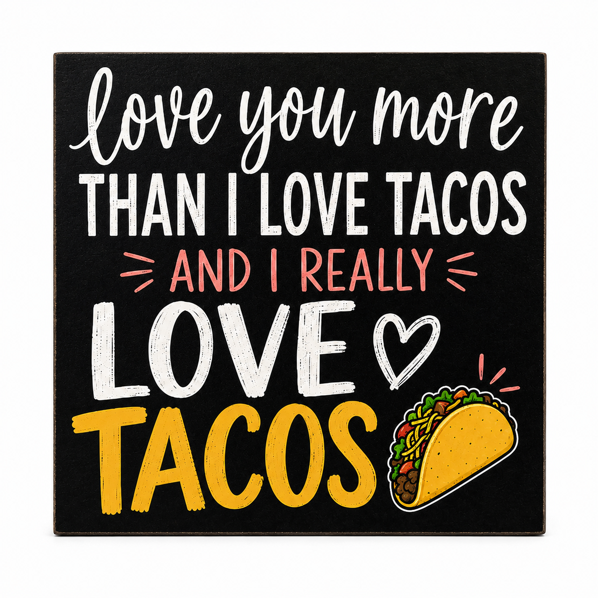 A square black decorative sign with white, coral, and yellow text reading 'love you more than I love tacos and I really love tacos,' plus a taco illustration, shown on a white background.
