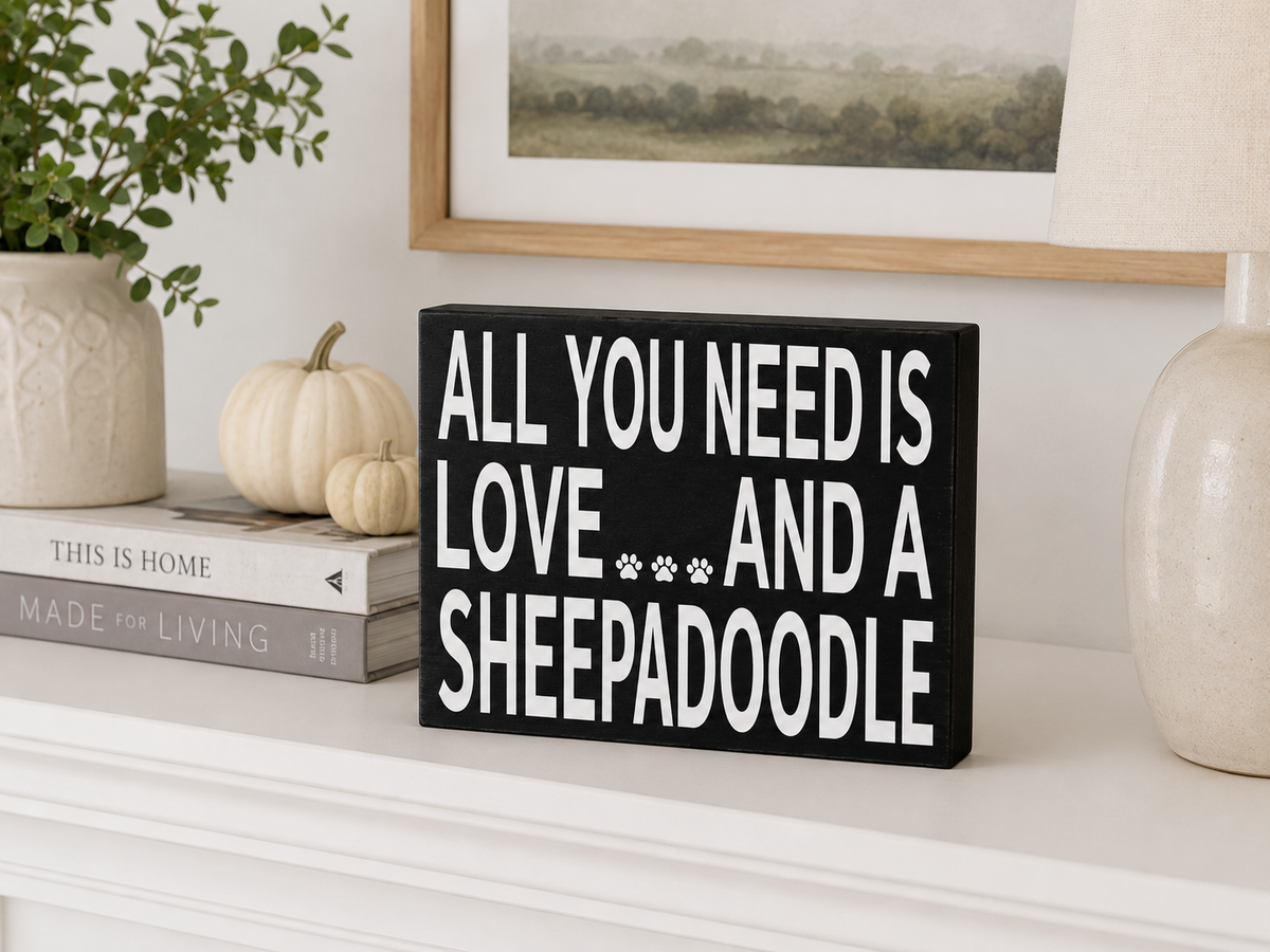 A rectangular black sign with white text reading 'ALL YOU NEED IS LOVE.