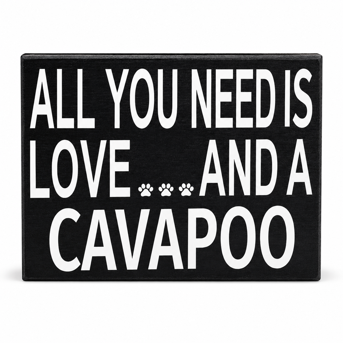 A rectangular black sign with bold white text reading 'ALL YOU NEED IS LOVE.