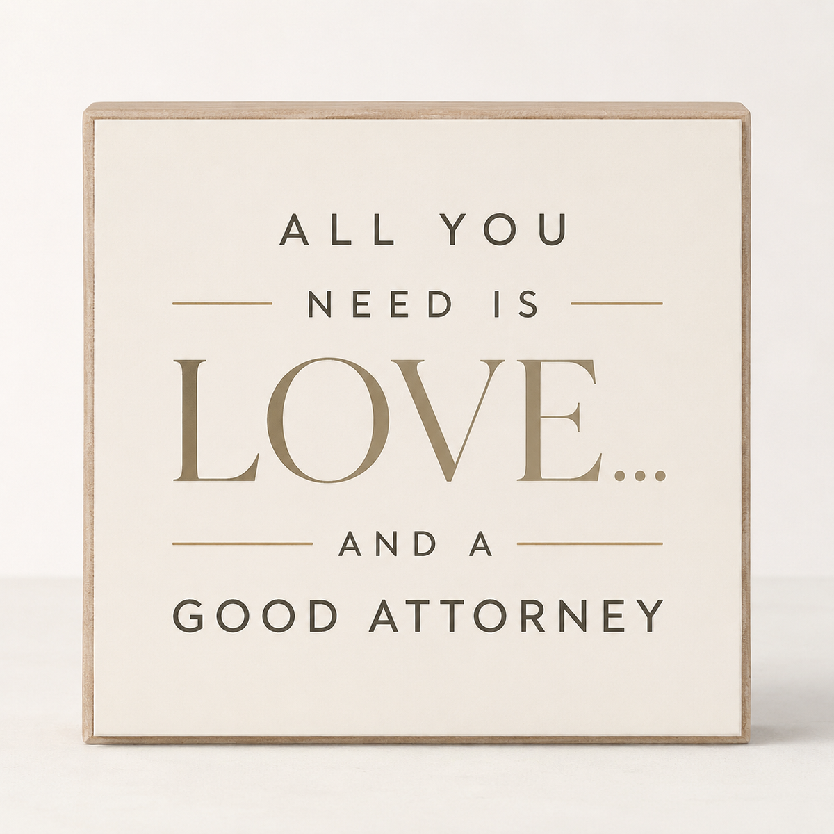 A square decorative sign with a light beige wood border and a cream face, featuring the text 'ALL YOU NEED IS LOVE.