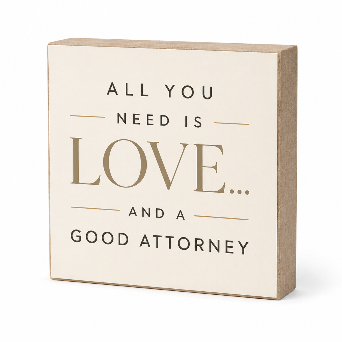 A square decorative block sign with a cream face and natural wood sides, printed with the phrase 'ALL YOU NEED IS LOVE.