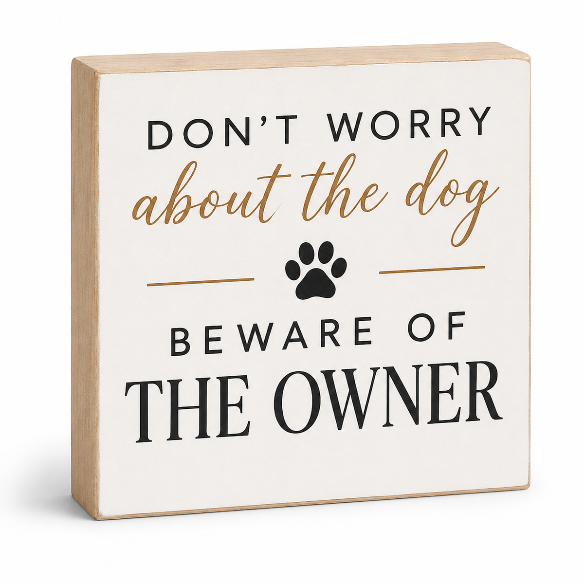 A square decorative wooden sign with a light natural wood frame and an off-white face. The sign features the humorous phrase 'DON'T WORRY about the dog BEWARE OF THE OWNER' in black and tan lettering, with a black paw print graphic in the center, shown on a clean white background.