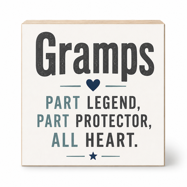 A square wooden block sign with a light natural wood border and a cream face, printed with the phrase 'Gramps Part Legend, Part Protector, All Heart.' in dark gray and muted blue-gray lettering with small heart and star icons, shown on a white background.