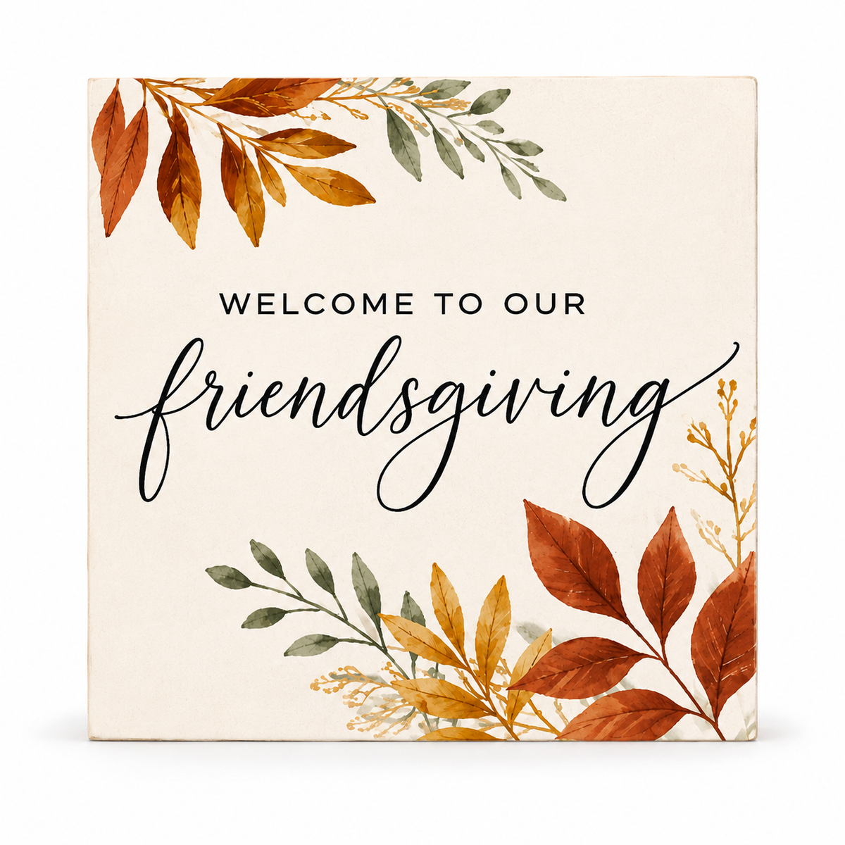 Square decorative sign with the words “WELCOME TO OUR friendsgiving” in black text, surrounded by autumn watercolor leaves in orange, brown, and muted green on a warm cream background.