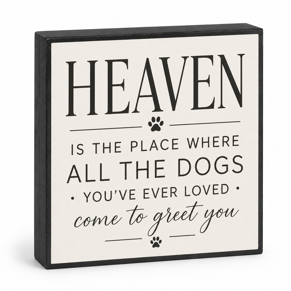 Square decorative wall sign with a black frame and cream face, printed with the phrase “HEAVEN IS THE PLACE WHERE ALL THE DOGS YOU’VE EVER LOVED come to greet you” plus small paw prints, shown on a light gray background.