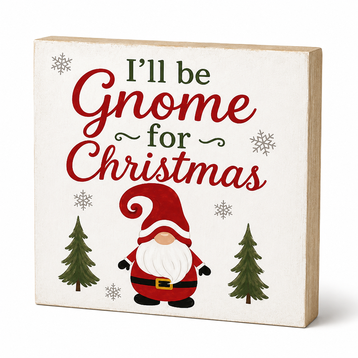 A square decorative wooden sign with a cream face and natural wood edges, featuring the phrase “I’ll be Gnome for Christmas” in red and green lettering, with a small gnome illustration, two green trees, and snowflakes.