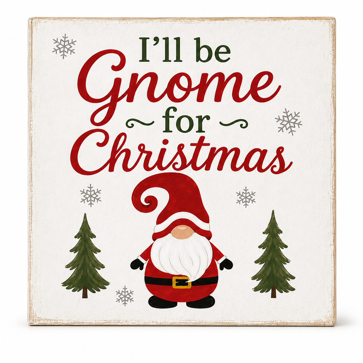 Square decorative sign with the phrase “I’ll be Gnome for Christmas” in red and dark green lettering, featuring a cartoon gnome in a red hat and coat with a white beard, plus small gray snowflakes and green trees on an off-white background.