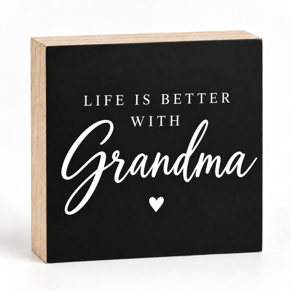 A square decorative wooden sign with a black front panel and natural wood sides. The sign reads “LIFE IS BETTER WITH Grandma” in white lettering, with a small white heart below the word “Grandma,” on a clean white background.