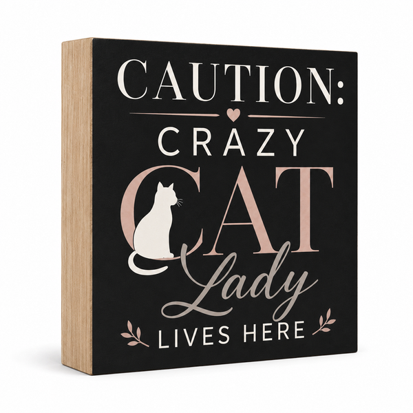 A square decorative wall sign with a black front and natural wood side edges. The sign reads “CAUTION: CRAZY CAT Lady LIVES HERE” in white and blush lettering, with a white cat silhouette and small leaf motifs.