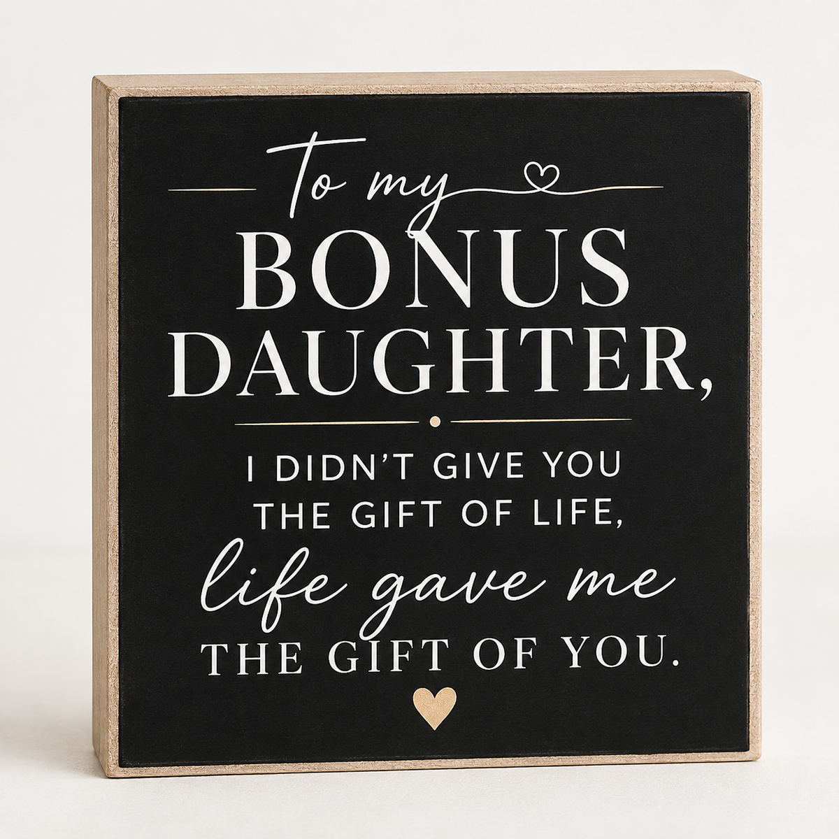 A square decorative sign with a black face and natural wood border, featuring white and light beige text that reads, 'To my BONUS DAUGHTER, I DIDN'T GIVE YOU THE GIFT OF LIFE, life gave me THE GIFT OF YOU.' with small heart accents, shown on a light neutral background.