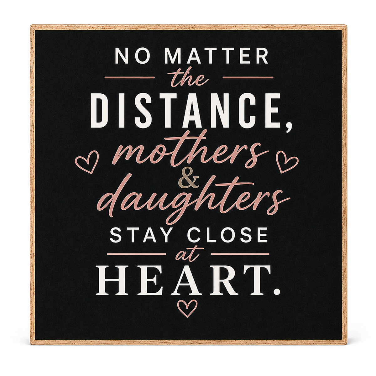 Square wooden sign with a black face and natural wood border, featuring the phrase 'NO MATTER the DISTANCE, mothers & daughters STAY CLOSE at HEART.' in white and blush pink lettering with small heart accents, shown on a white background.