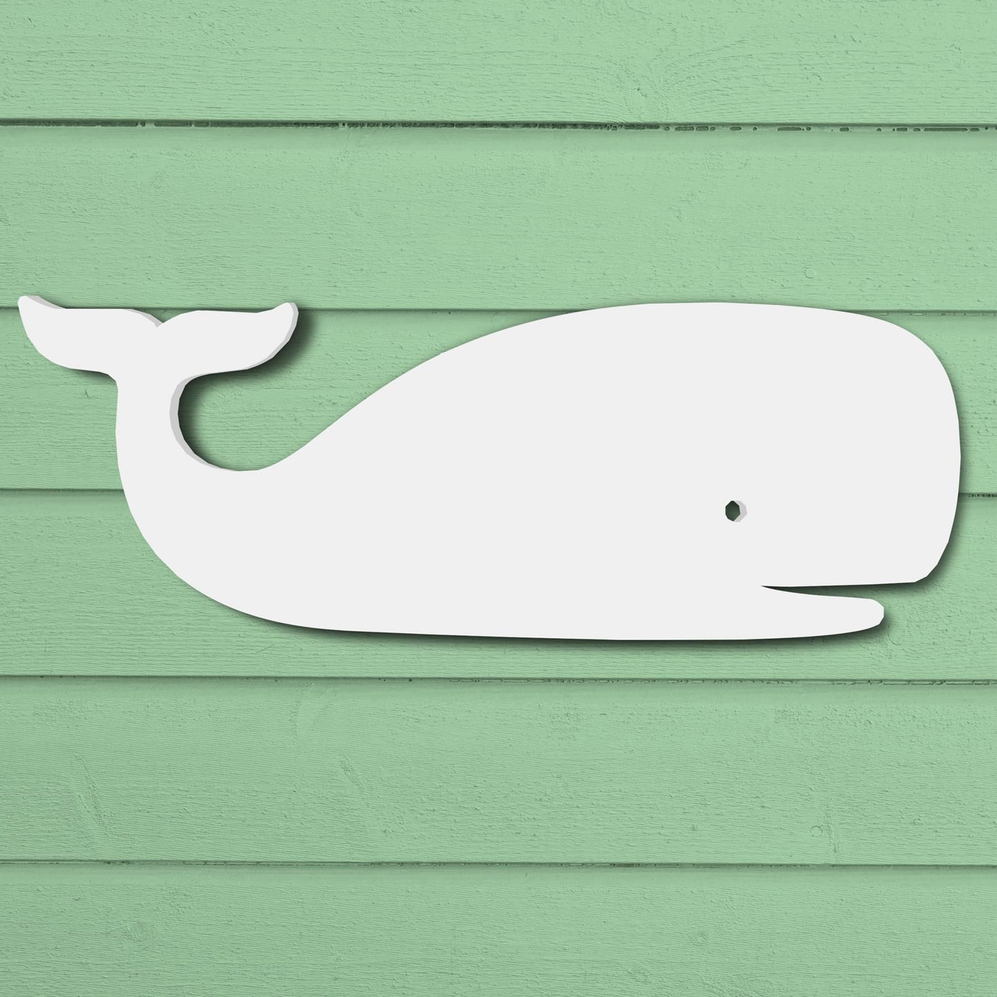Durable white PVC whale silhouette wall art for outdoor coastal home decor with a green wood background.