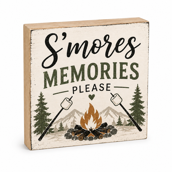 A square wooden decorative sign with a rustic distressed cream background and a light natural wood edge. The sign features the text 'S'mores MEMORIES PLEASE' in black and dark green lettering, with an illustration of a campfire, mountains, pine trees, and marshmallows roasting on sticks.