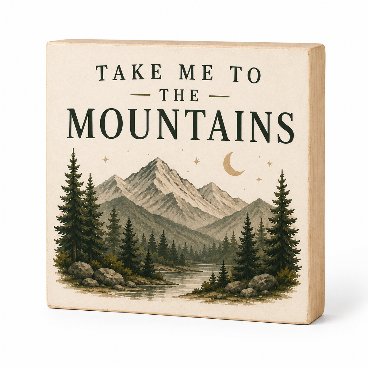 A square wooden block sign with a light natural wood frame and a cream-colored face, printed with the text 'TAKE ME TO THE MOUNTAINS' above an illustrated mountain landscape with pine trees, stars, and a crescent moon.