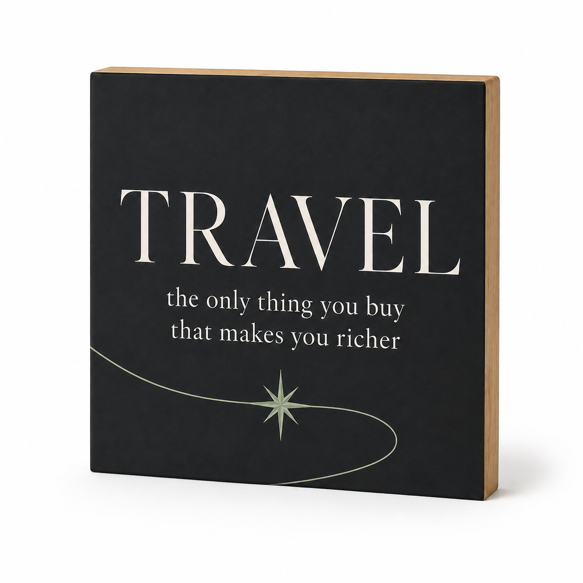 A square decorative wall sign with a black front and natural wood sides, featuring the word 'TRAVEL' in large white letters and the quote 'the only thing you buy that makes you richer' below, on a white background.