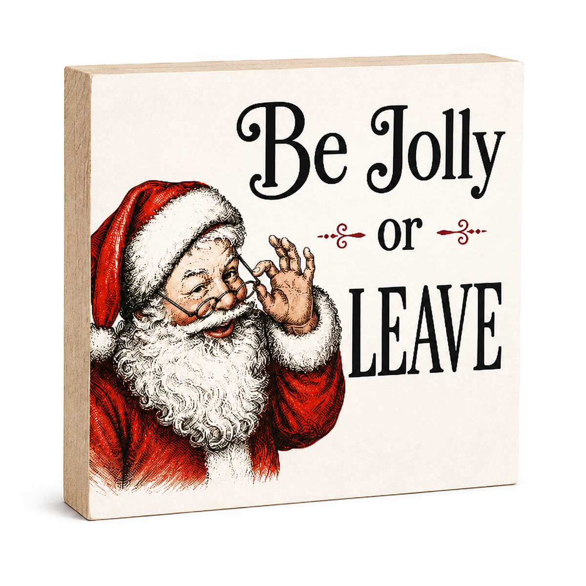 A square decorative wooden sign with a light natural wood edge and a cream face, printed with the phrase 'Be Jolly or LEAVE' in black script and block lettering, alongside an illustration of Santa Claus in red and white.