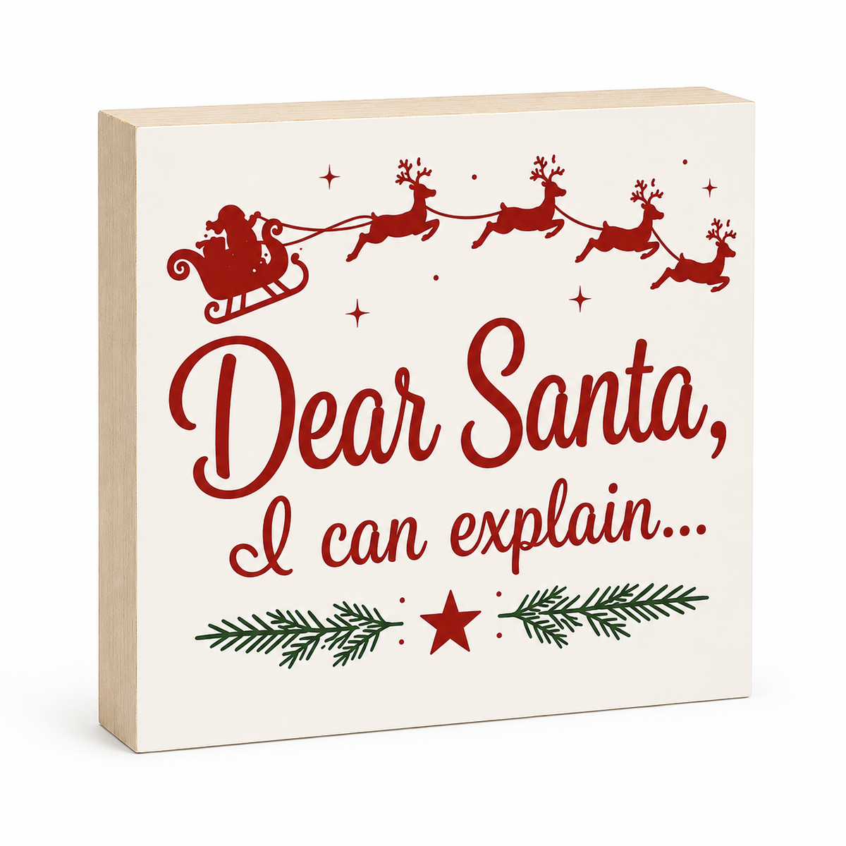A square decorative wooden sign with a light natural wood edge and a cream face, printed with a red Santa and reindeer silhouette and the phrase 'Dear Santa, I can explain.