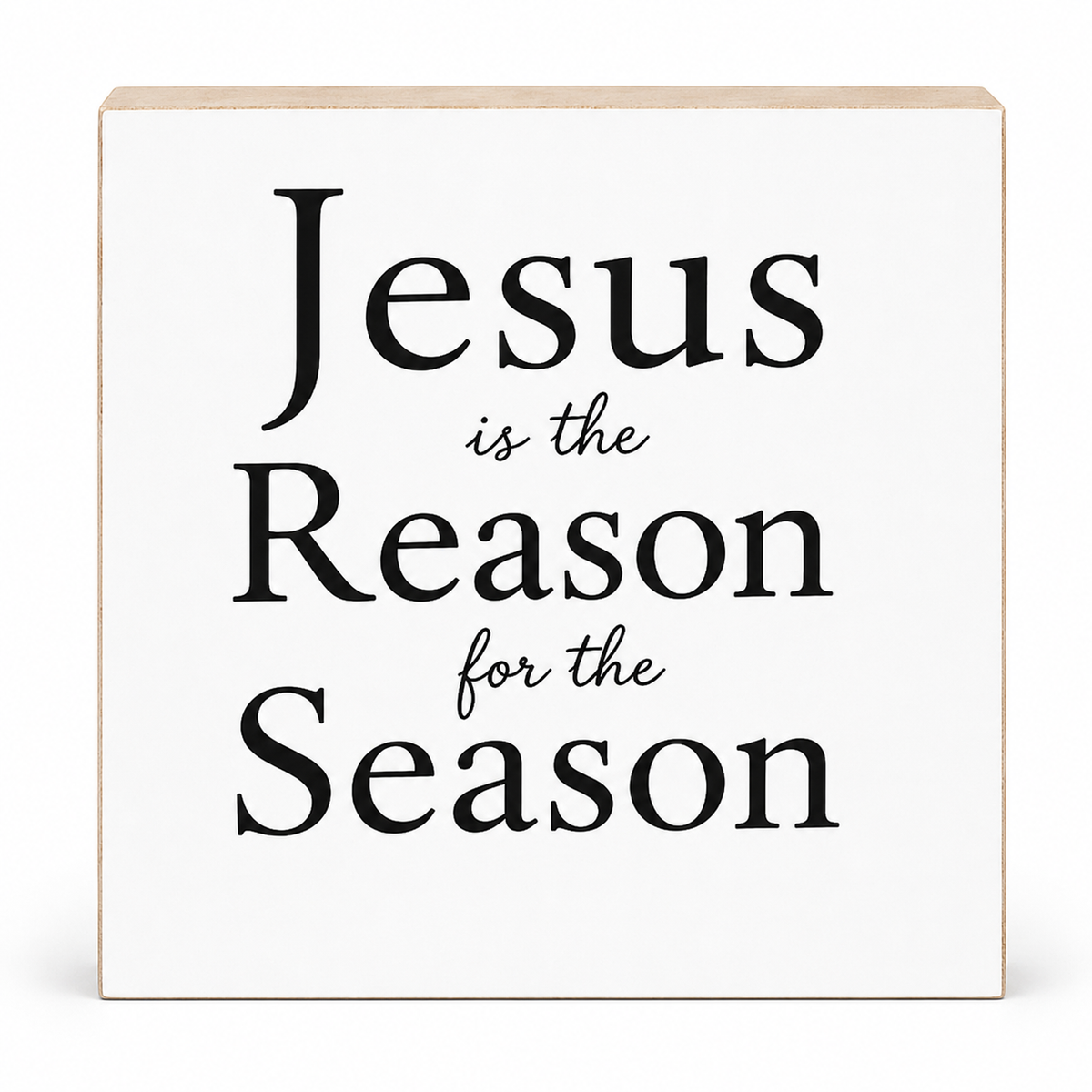 A square white decorative sign with a light natural wood edge and black text reading 'Jesus is the Reason for the Season' on a clean white background.