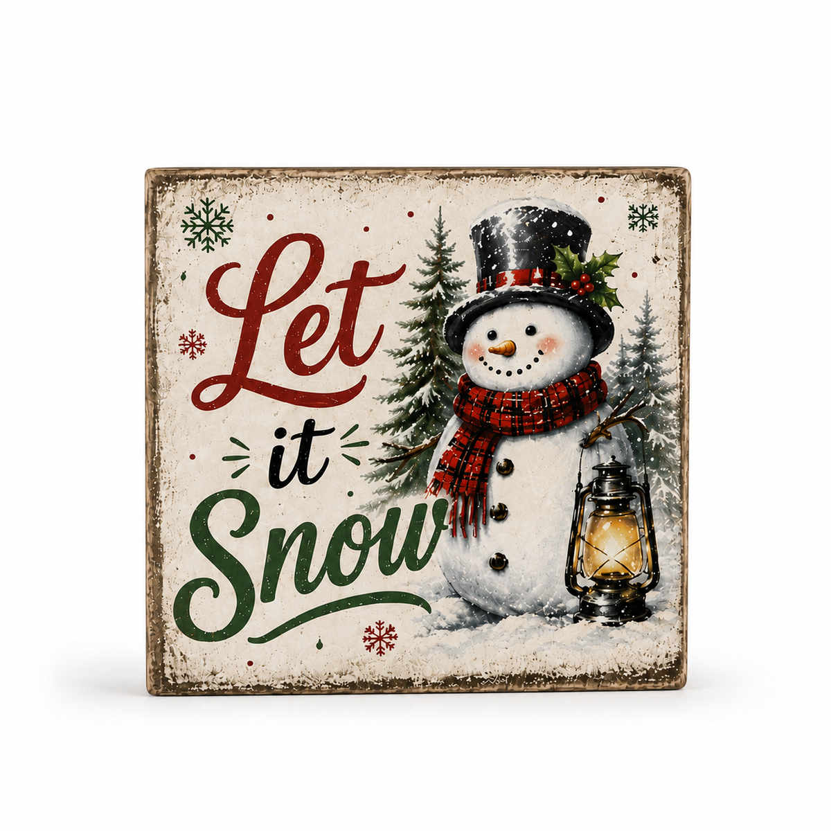 A square decorative sign with a distressed cream background featuring the phrase 'Let it Snow' in red, black, and green lettering, alongside an illustrated snowman in a top hat and scarf next to a lantern.