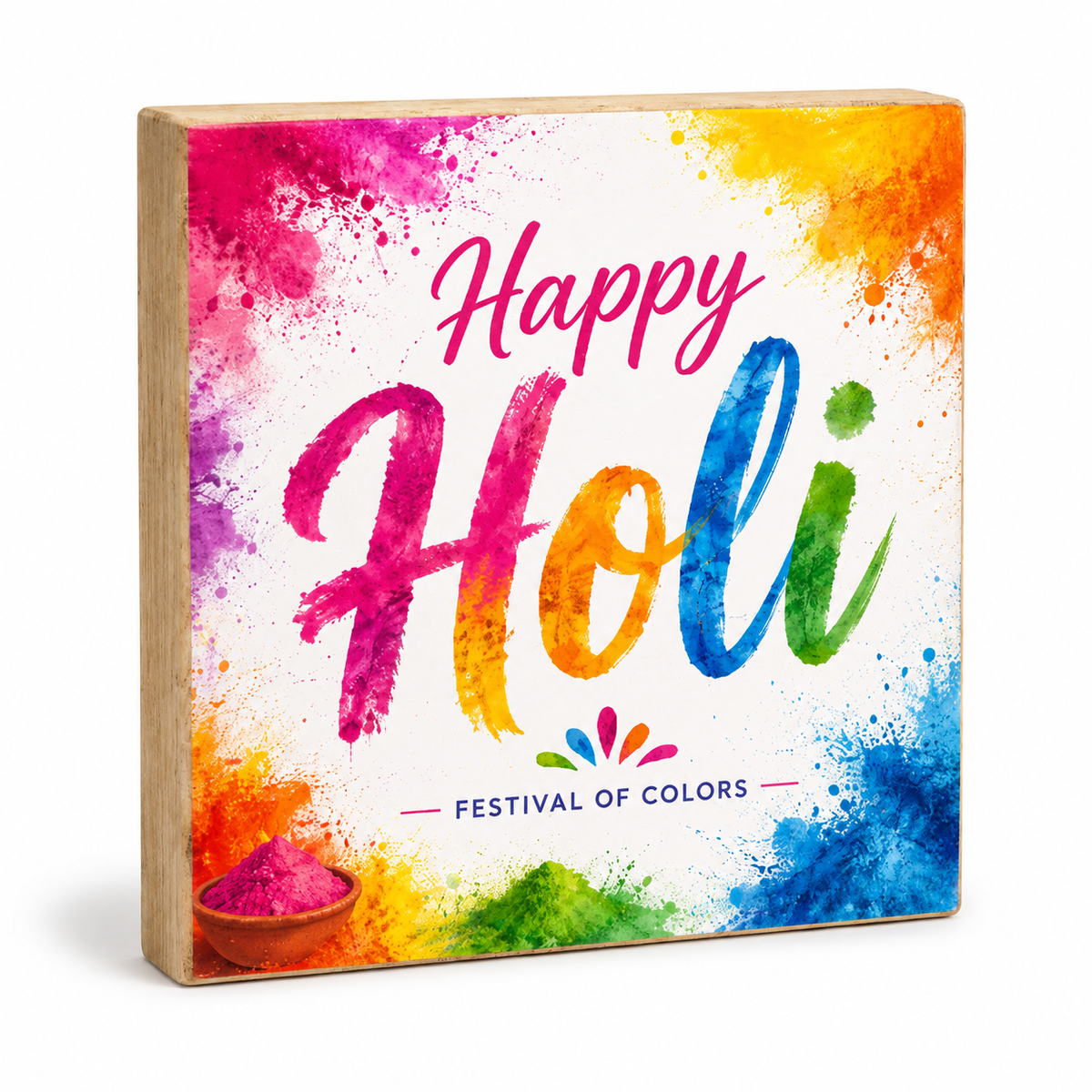 A square wooden decorative block sign featuring a colorful Holi-themed design with the words 'Happy Holi' and 'FESTIVAL OF COLORS' on a white background with bright paint splatters.