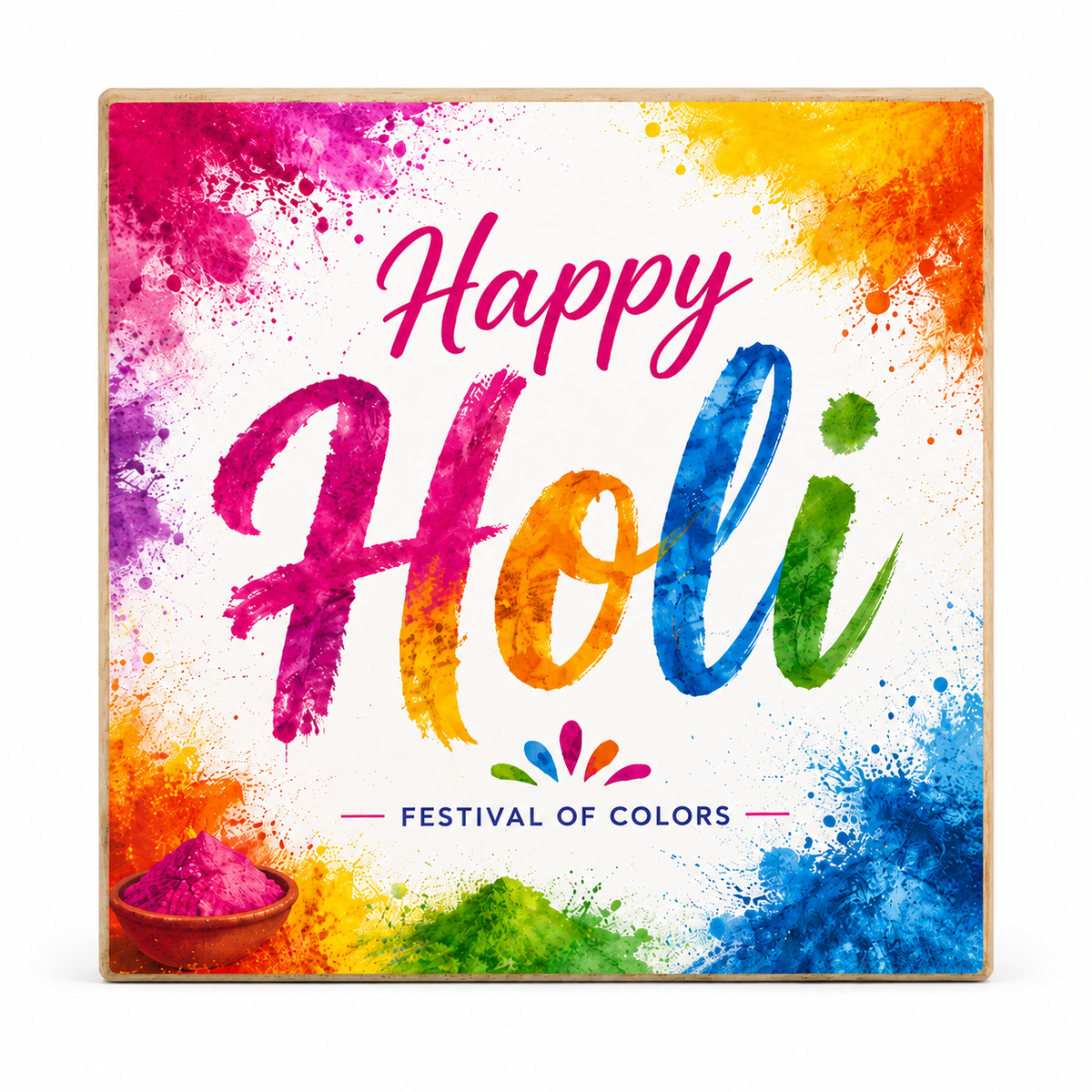 Square decorative wall art sign with a light wood frame featuring a colorful Holi design. The sign has a white center with large multicolor brushstroke text reading 'Happy Holi,' additional colorful text 'FESTIVAL OF COLORS,' and watercolor splashes in pink, orange, yellow, blue, green, and purple, plus small illustrations of colored powder piles in the lower left and bottom center.