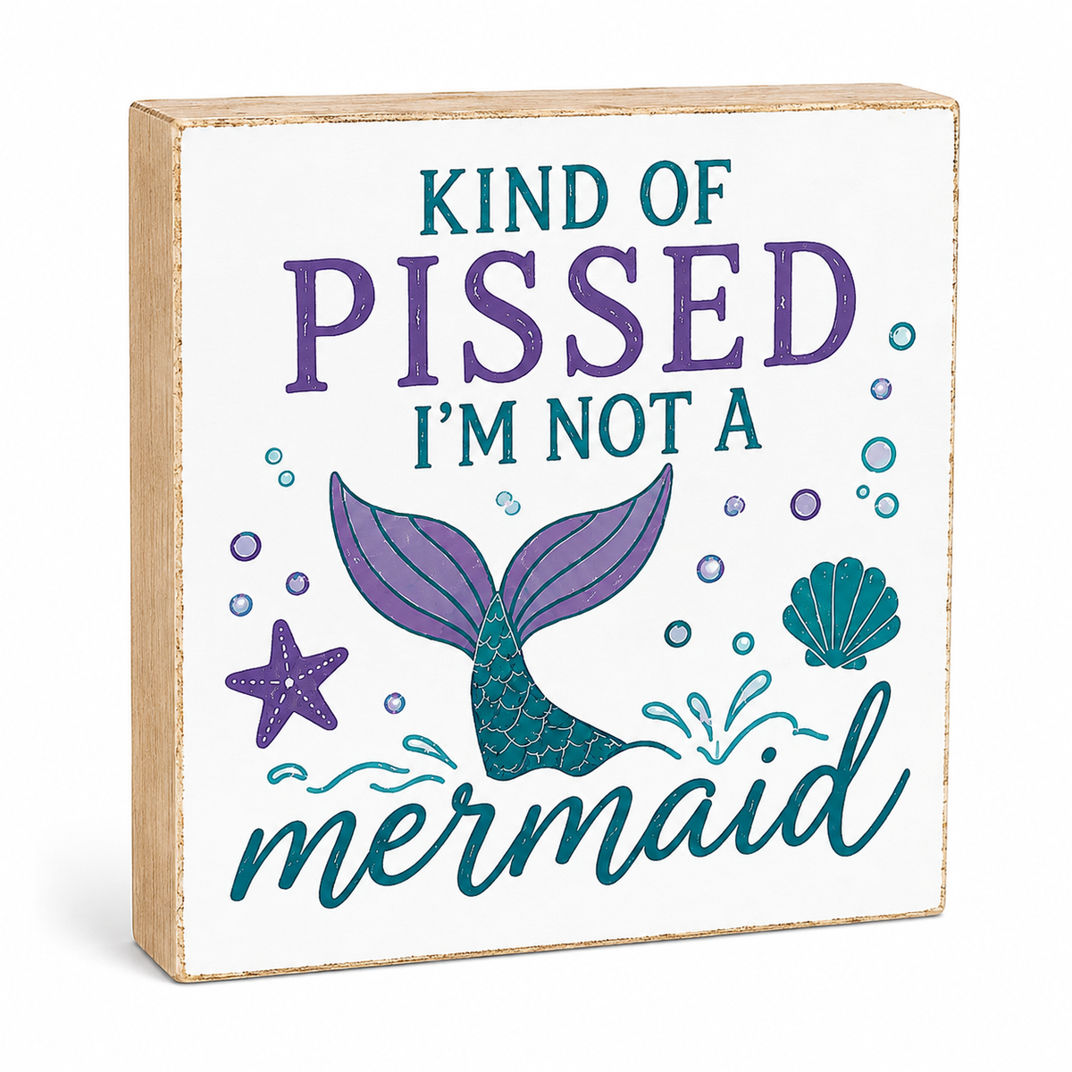 A square wooden decorative sign with a white face, light natural wood edges, and printed text reading 'KIND OF PISSED I'M NOT A mermaid' with a purple and teal mermaid tail, starfish, shell, and bubble illustration.