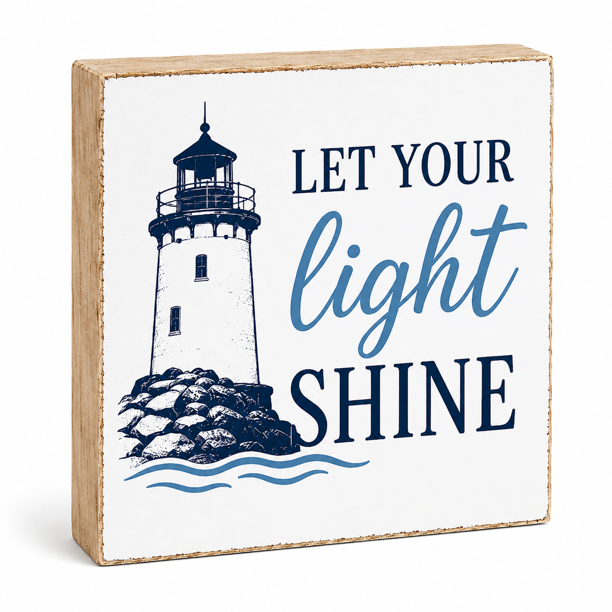 A square decorative wooden block sign with a natural wood edge, featuring a navy blue lighthouse illustration and the phrase 'LET YOUR light SHINE' on a white front panel, shown on a clean white background.
