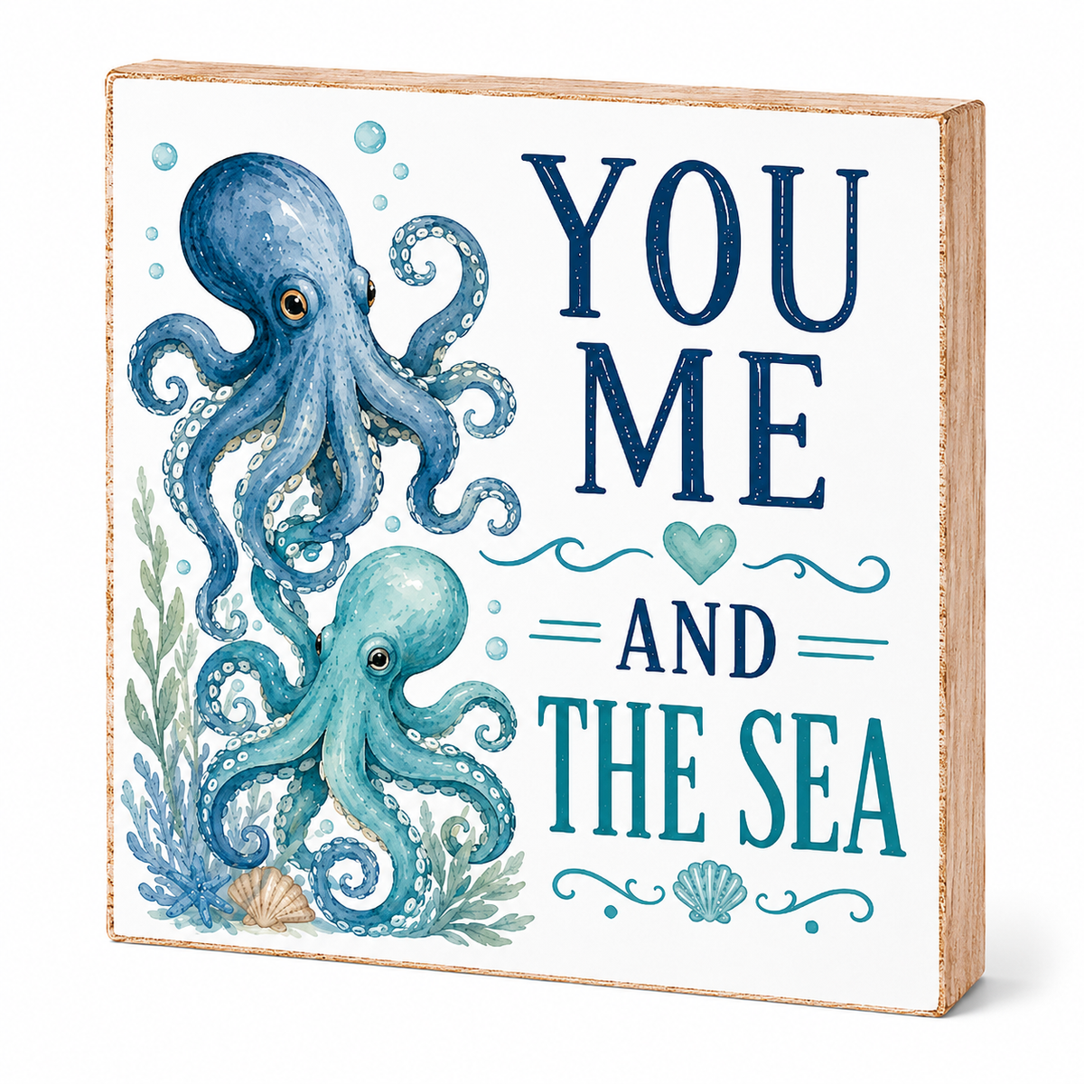 Square decorative block sign with a light wood edge, featuring two blue octopuses and the phrase “YOU ME AND THE SEA” in navy and teal lettering on a white front face, shown on a light gray background.