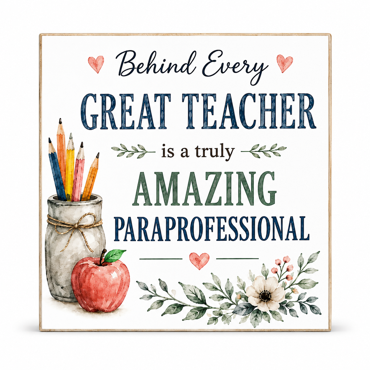 A square decorative sign with a light wood border and white background, featuring the text 'Behind Every GREAT TEACHER is a truly AMAZING PARaprofessional' in navy and green lettering, with watercolor-style illustrations of a jar of colored pencils, a red apple, and floral branches.