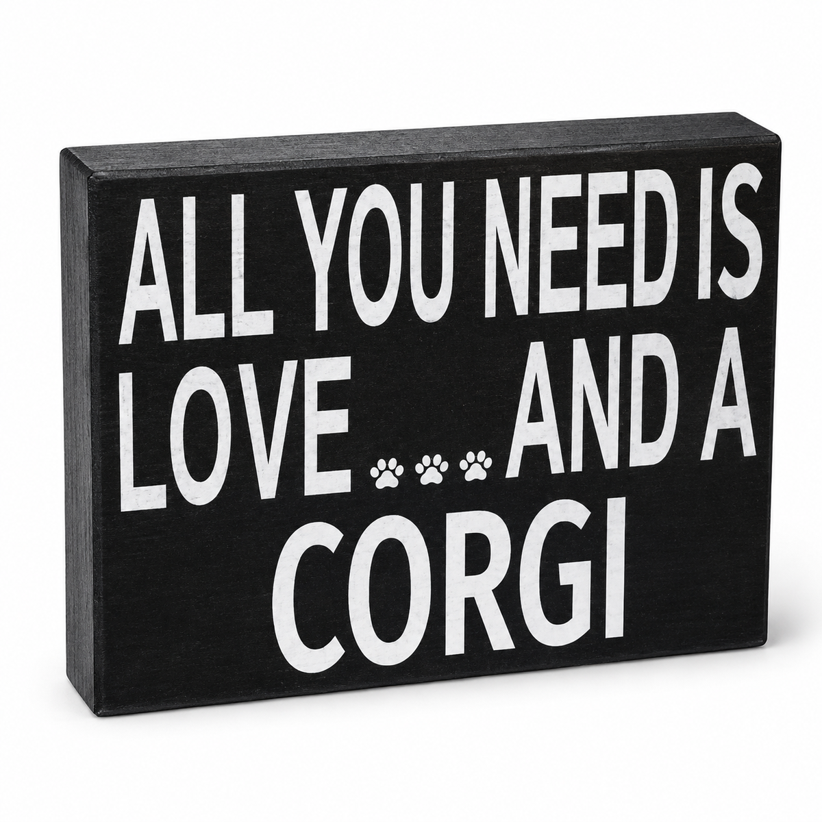 A rectangular black wooden sign with bold white text reading 'ALL YOU NEED IS LOVE.