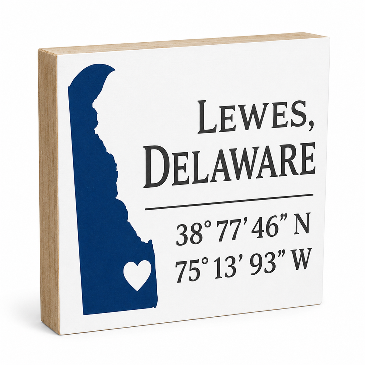A square decorative wooden sign with a light natural wood edge and a white front panel. The panel shows a dark blue silhouette of Delaware, the text 'LEWES, DELAWARE' in black, and coordinates below.