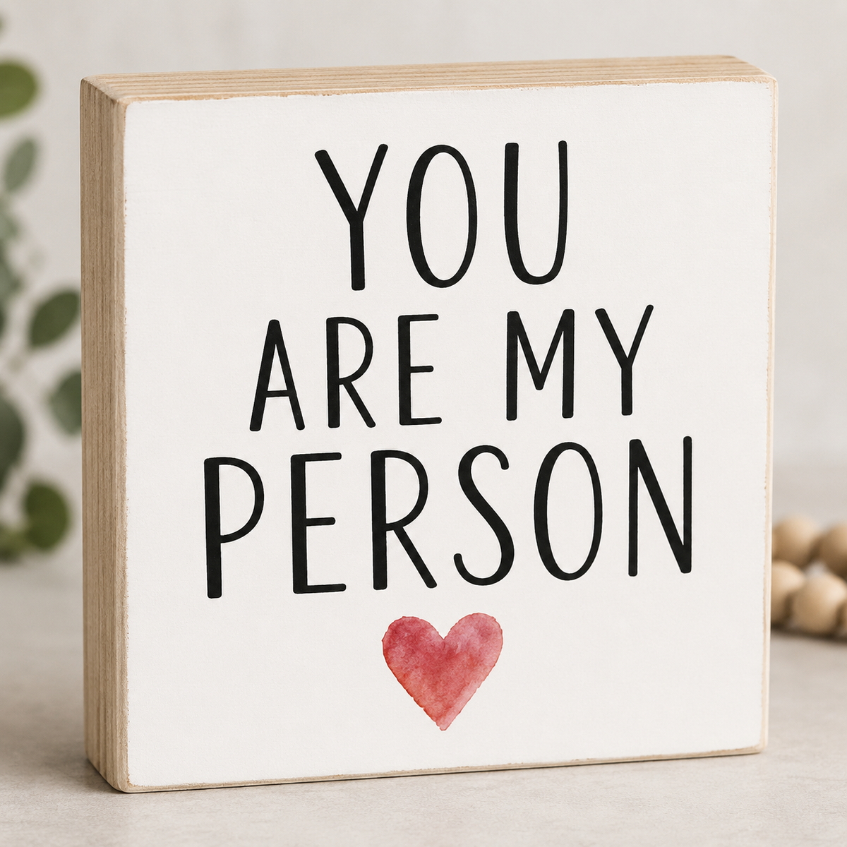 Wooden block with 'You are my person' text and a heart on a light background