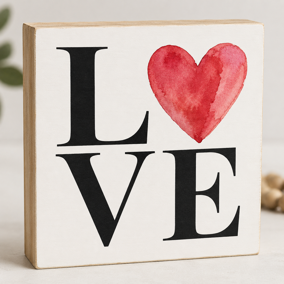 Decorative sign with 'LOVE' and a red heart on a white background