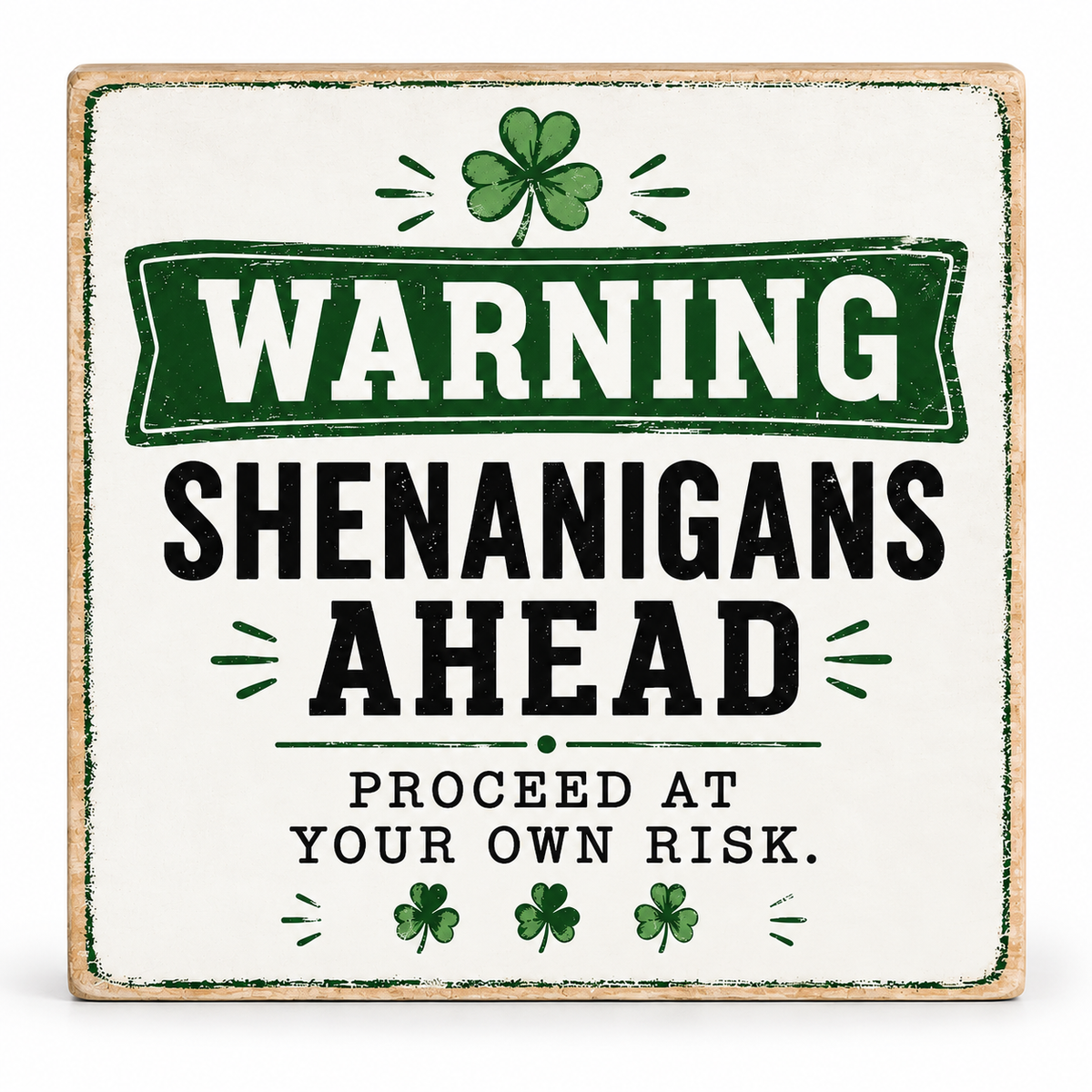 A square decorative sign with a distressed white background and a natural wood border. The sign features a green banner reading 'WARNING' above the words 'SHENANIGANS AHEAD' in large black letters, with smaller black text below reading 'PROCEED AT YOUR OWN RISK.
