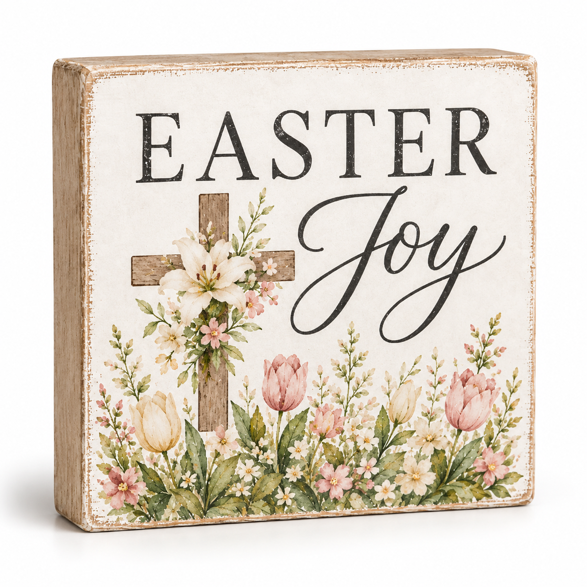 A square decorative wooden sign with a distressed cream face, reading “EASTER Joy” in black lettering above a floral arrangement with a wooden cross, tulips, lilies, and small wildflowers.