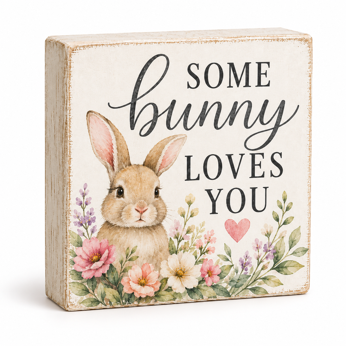 A square decorative wooden sign with a distressed cream background, featuring an illustration of a brown bunny surrounded by pink, peach, and white flowers with green leaves. The text reads 'SOME bunny LOVES YOU' in black lettering, with a small pink heart.