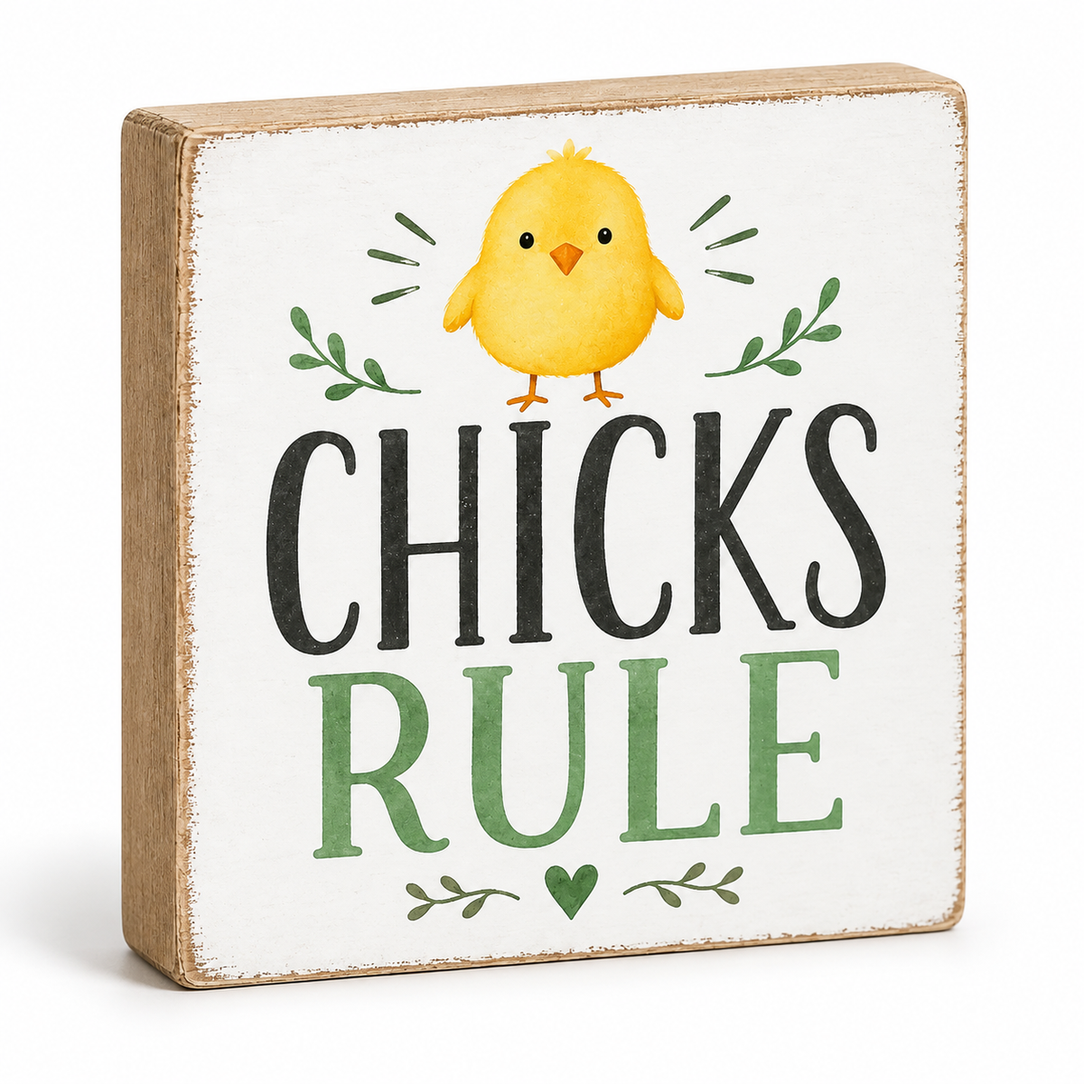 A square decorative block sign with a rustic wood edge and a white front, featuring a yellow chick illustration above the words “CHICKS RULE” in black and green lettering.