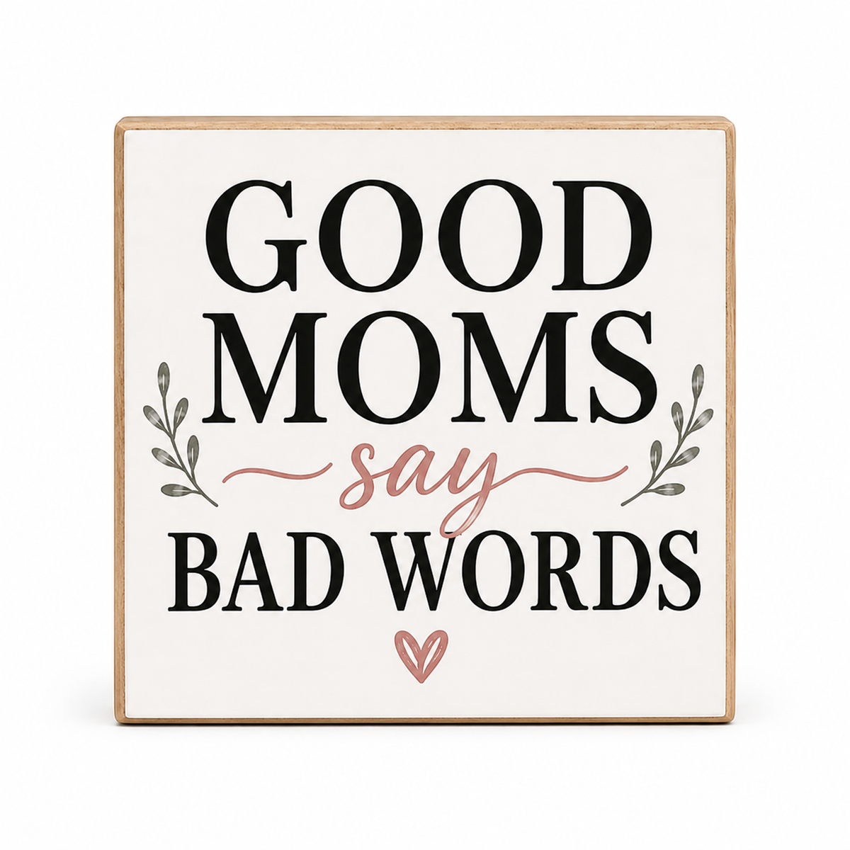 Square decorative sign with the phrase “GOOD MOMS say BAD WORDS” in black lettering, with a dusty pink script word and small leafy accents, shown on a white background.