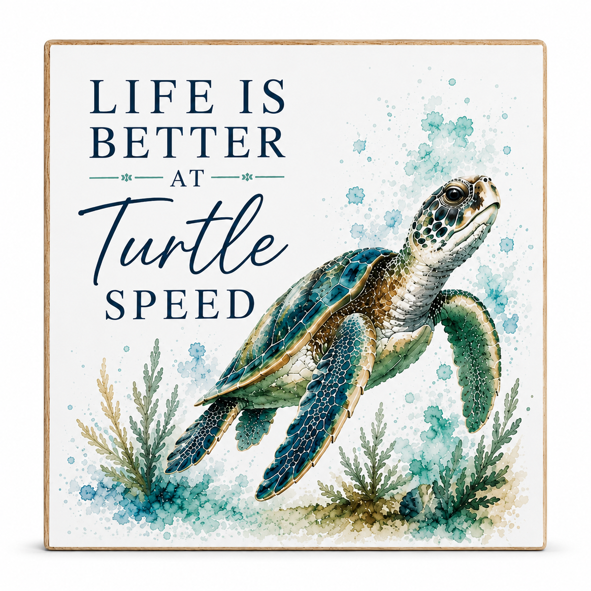 Square decorative wall sign with a watercolor sea turtle illustration and the phrase “LIFE IS BETTER AT Turtle SPEED” in navy text on a white background with blue watercolor splashes and sea plants.