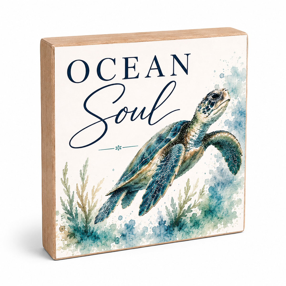 A square decorative wooden block sign with a light natural wood border and a printed ocean-themed design. The front shows the words “OCEAN Soul” in dark navy lettering above a painted sea turtle in blue, teal, and brown tones, with watercolor-style sea plants at the bottom.