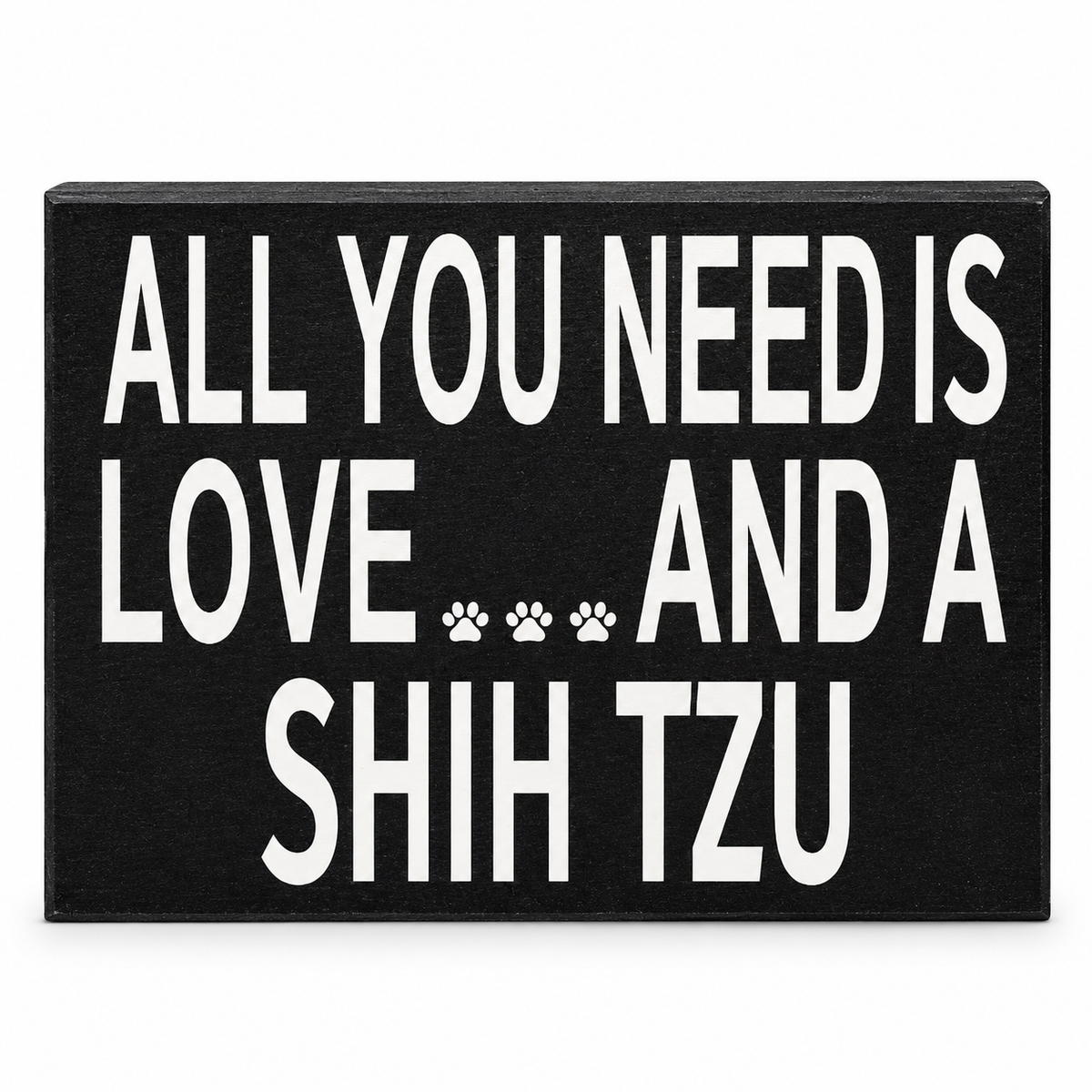 A rectangular black sign with bold white text reading 'ALL YOU NEED IS LOVE.