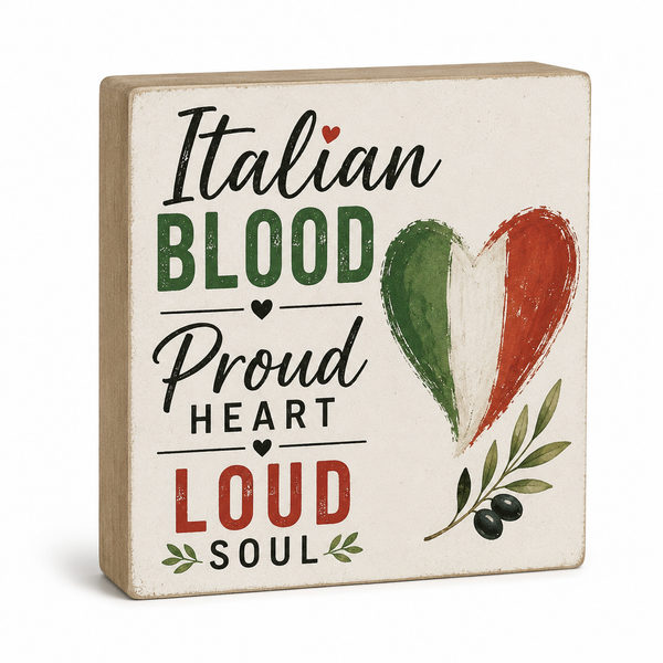 A square decorative wooden sign with a light natural wood border and a distressed off-white face. The sign features the text 'Italian Blood Proud Heart Loud Soul' in black, green, and red lettering, alongside a painted heart in the Italian flag colors and a small olive branch with black olives.
