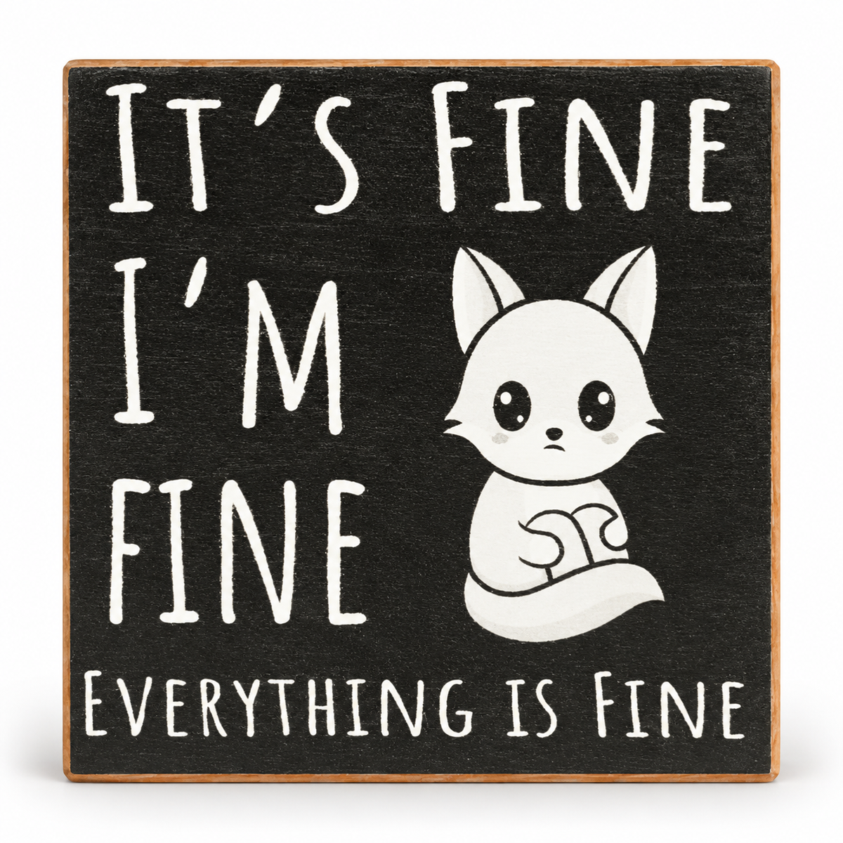 A square decorative sign with a dark charcoal background and a light wood border. The sign features the phrase 'IT'S FINE I'M FINE EVERYTHING IS FINE' in large white hand-drawn-style letters, alongside a white cartoon fox sitting in the center.