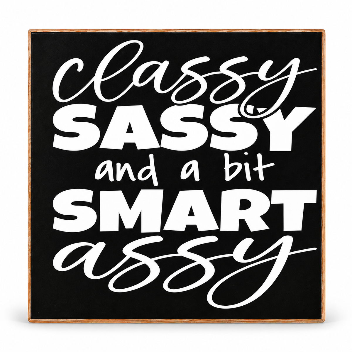 A square decorative sign with a black face, white typographic text reading 'classy SASSY and a bit SMART assy,' and a thin natural wood border, shown on a plain white background.