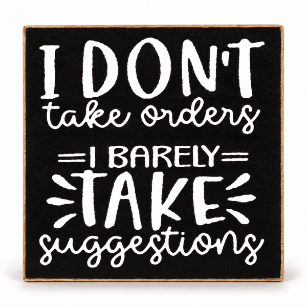 A square decorative sign with a black face and natural wood border, featuring white hand-lettered text that reads, 'I DON'T take orders I BARELY TAKE suggestions' on a white background.