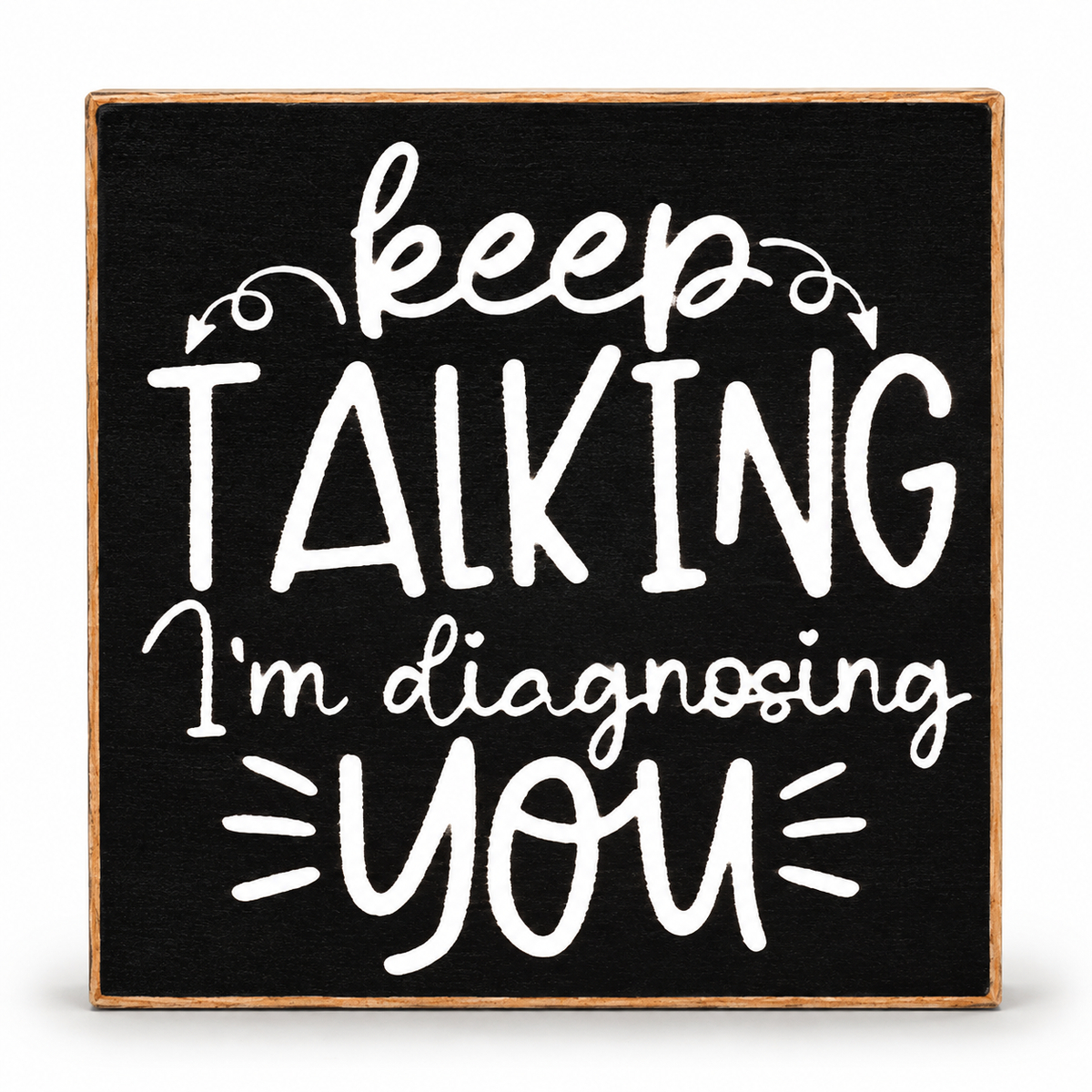 A square decorative sign with a black face and natural wood border, featuring white hand-lettered text that reads, 'keep TALKING I'm diagnosing YOU' on a clean white background.