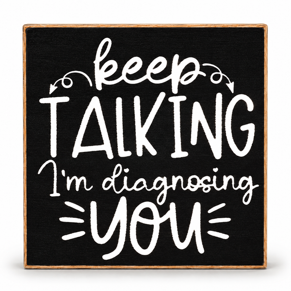 A square decorative sign with a black face and natural wood border, featuring white hand-lettered text that reads, 'keep TALKING I'm diagnosing YOU' on a clean white background.