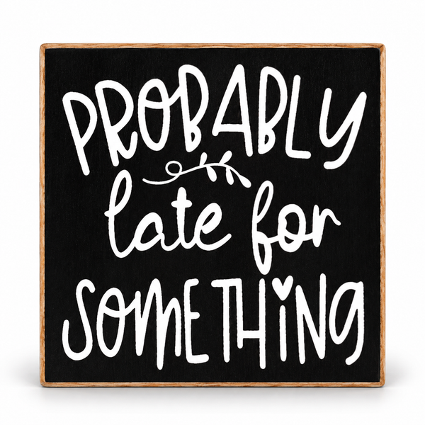 Square decorative wall sign with a black face and natural wood border, featuring the phrase “PROBABLY late for SOMETHING” in large white handwritten-style lettering, shown on a white background.