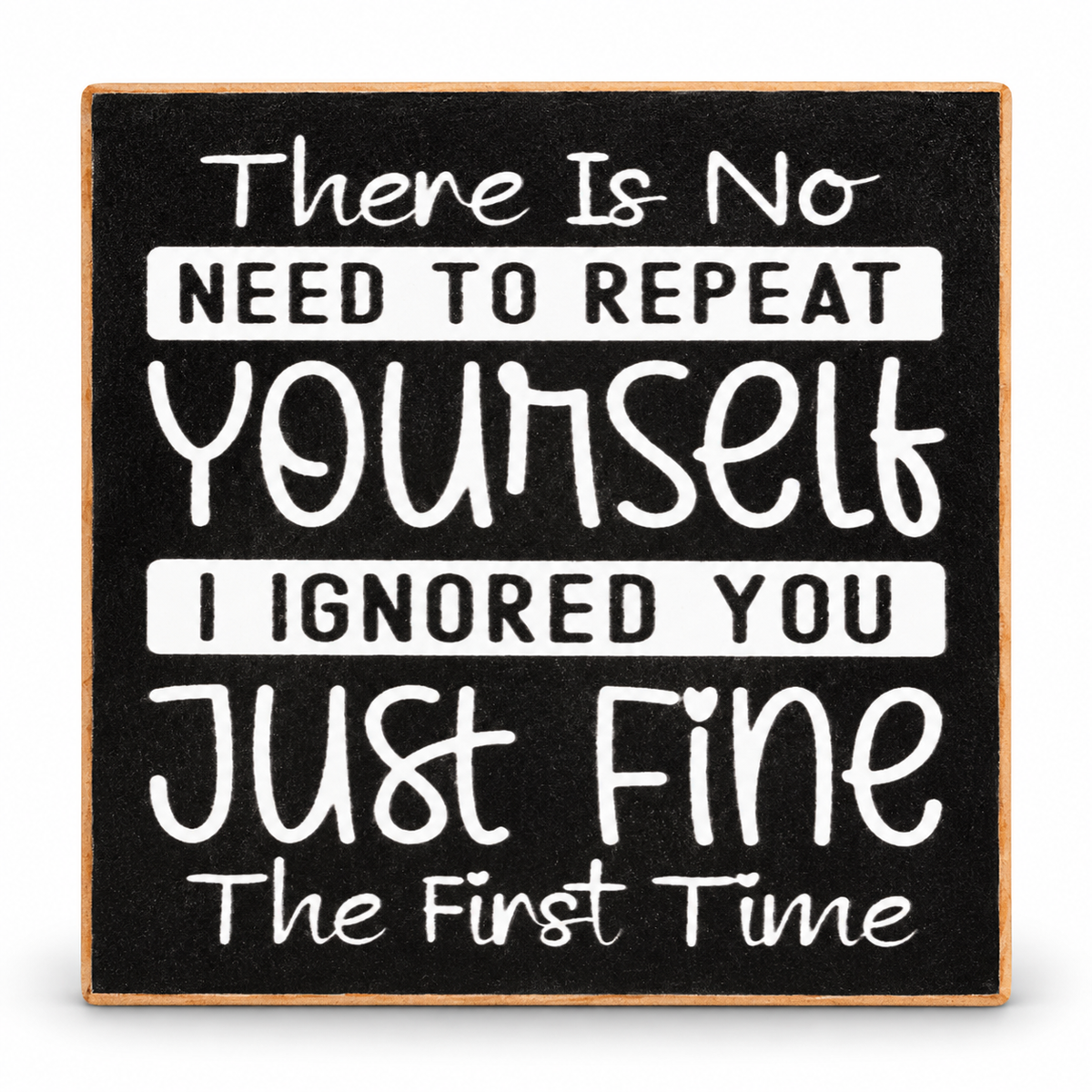 Square decorative sign with a black chalkboard-style background and a light wood border. White hand-lettered text reads, 'There Is No NEED TO REPEAT Yourself I IGNORED YOU Just Fine The First Time.
