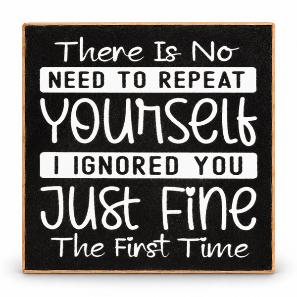 Square decorative sign with a black chalkboard-style background and a light wood border. White hand-lettered text reads, 'There Is No NEED TO REPEAT Yourself I IGNORED YOU Just Fine The First Time.